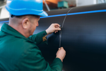 worker checks diameter with a tape measure. pvc