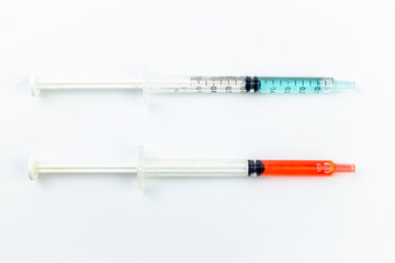 Fototapeta premium Medical syringe with red and blue liquid isolated on white background.