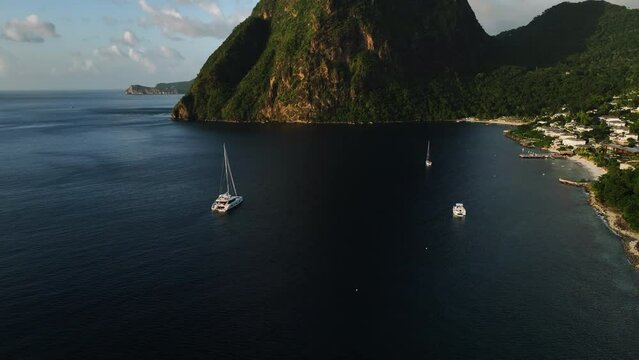 Gros Piton mountain and the Jalousie town, sunset in St lucia - Aerial tilt reveal