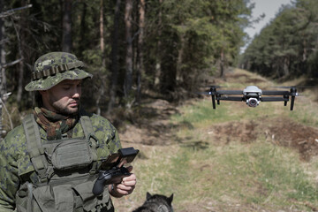Military soldier reconnaissance launches a drone in the forest.