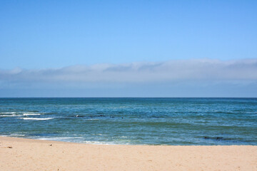 Fototapeta na wymiar Empty sandy beach with turquoise sea waves. Summer seascape.