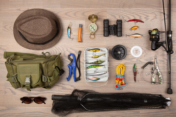 Fishing rod, tackles and other stuff for recreation activity on the wooden desk. Fishing season...