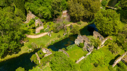 Aerial view of the ruins located in the garden of Ninfa, near Latina, Italy. The park is an Italian natural monument and contains exotic plants from various parts of the world. - obrazy, fototapety, plakaty