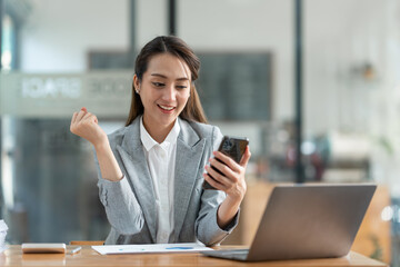 Obraz premium Attractive Asian businesswoman doing business related to village building project contacting using a mobile phone to chat and Negotiate management ideas in her office.