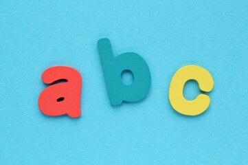 Alphabet wooden colored letters on blue background. Education and back to school concept. Foreign...