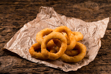 Breaded squid rings on a wooden background.