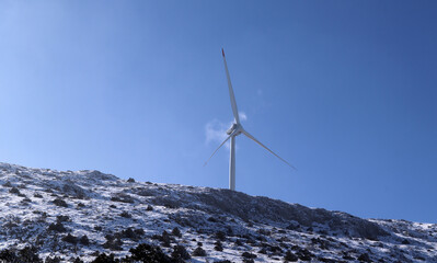 Wind turbine against blue sky.