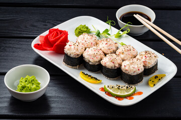 Set of sushi rolls with white fish, crab meat, cream cheese, avocado, wasabi, ginger and soy sauce.