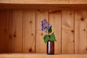 One vase with flowers at wooden background from side view
