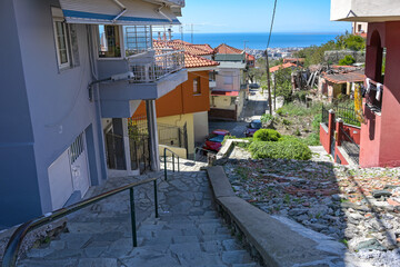 Narrow footpath in Ani Poli, the historic upper old town of Thessaloniki, Greece, with stone paved...