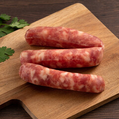 Raw Taiwanese sausage in garlic flavor in a plate on wooden table background.