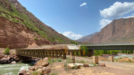 Beautiful mountain landscape with a stormy river flowing under two bridges. Panorama of a mountain...