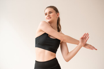 Fototapeta premium Young woman dressed in sportswear doing fitness exercises at home