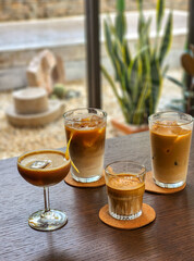 A group of iced coffee on wooden table in cafe.