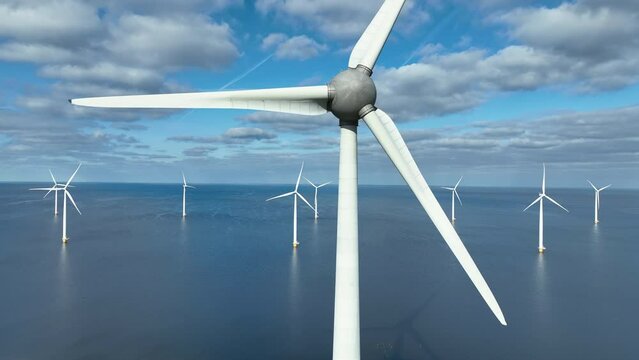 Wind turbines in an offshore wind park or wind farm during springtime seen from above.