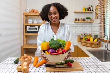 Tuinposter  African American housewife is showing variety of organic vegetables to prepare simple and easy cajun southern style salad meal for vegan and vegetarian soul food concept © Akarawut