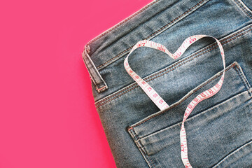 blue jeans with measure tape in pocket in form of a heart. - obrazy, fototapety, plakaty