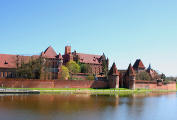 Medieval red brick castle on the river bank.