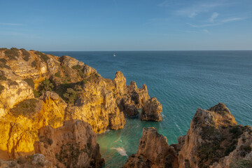 Fototapeta na wymiar Ponta da Piedade (point of mercy) a headland with dramatic yellow-golden cliff-like rock formations, arches and grottos along the coastline of the town of Lagos, Algarve, Portugal