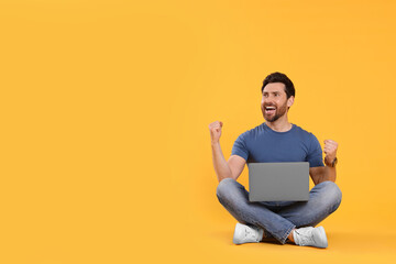 Emotional man with laptop on yellow background. Space for text