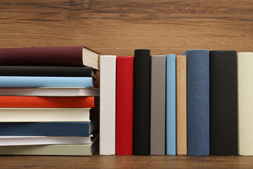 Many different hardcover books on wooden table
