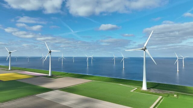 Wind turbines on a levee and offshore in Flevoland The Netherlands, during springtime seen from above. Flevoland is a modern polder in the former Zuiderzee designed initially to create more land for f