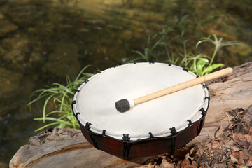 Modern drum and drumstick on stump outdoors. Percussion musical instrument