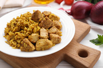 Plate of delicious rice with chicken on white table, closeup