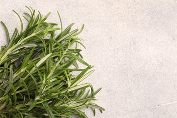 Fresh rosemary on light textured table, top view. Space for text