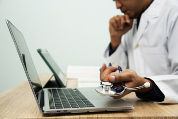 Medicine doctor in medical uniform working with computer notebook at desk in the hospital