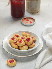 Homemade thumb print cookies filled with strawberry jam and grated cheese
