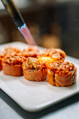 professional chef's hands making sushi roll in a restaurant kitchen