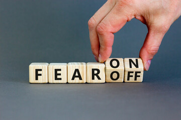 Fear on or off symbol. Businessman turns wooden cubes and changes word Fear off to Fear on. Beautiful grey table grey background. Business and fear on or off concept. Copy space.