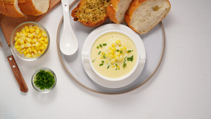 Corn Soup and Bread breakfast menu on white table
