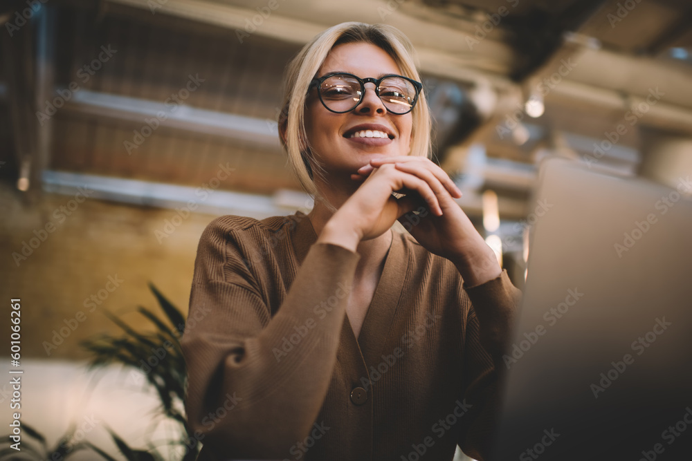 Poster portrait of cheerful caucasian female with blurred laptop smiling at camera during time for web netw