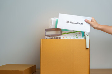 Resignation, Layoff, Unemployment, Dismiss, Job quit, Jobless and Farewell concept. Businesswoman holding letter of Resign contract with documents cardboard box at office