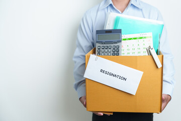 Resignation, Layoff, Unemployment, Dismiss, Job quit, Jobless and Farewell concept. Businessman holding letter of Resign contract with documents cardboard box at office