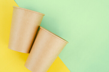 The Brown paper disposable eco-friendly cups on green background.