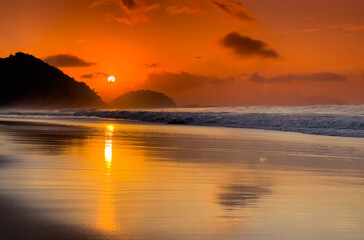 Beautiful orange sunrise over Copacabana Beach in Rio de Janeiro at the Atlantic Ocean shore. Amazing landscape of Brazil.