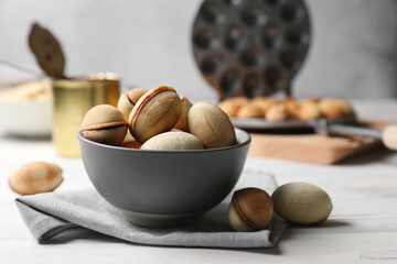 Delicious walnut shaped cookies with condensed milk on white wooden table, closeup