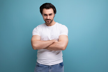 stylish brutal strong brunette man in a white T-shirt with muscles shows his power