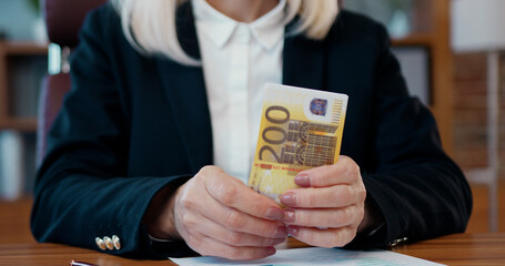 Close up of female hands which holding a lot of euros and doing calculation.Profit,money,income concept