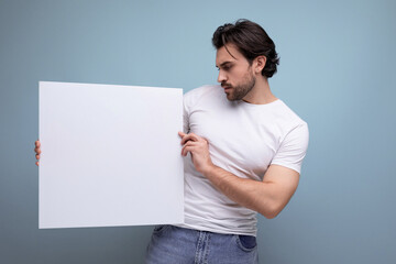 young brutal brunette guy shows a white board with a mockup for information