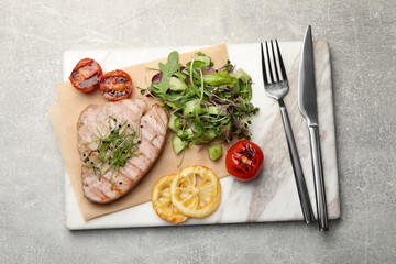 Delicious tuna steak served on light grey table, top view