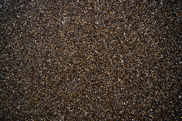 Feiner feuchter Kies am Strand als Hintergrundbild