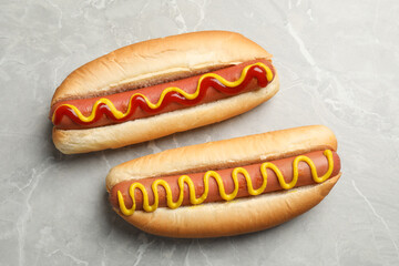 Delicious hot dog with mustard and ketchup on light grey table, flat lay