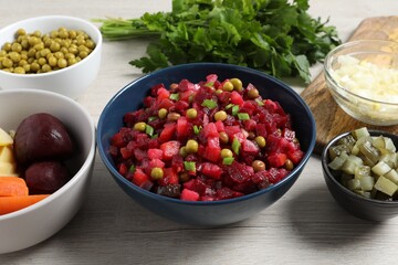 Bowl of delicious fresh vinaigrette salad and ingredients on wooden table