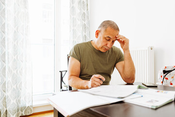 middle-aged man writes notes in notebook