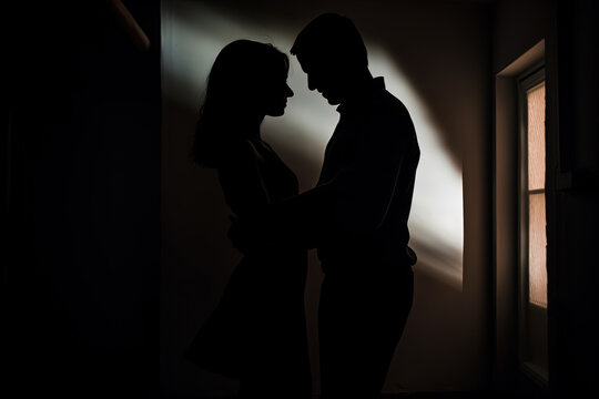 Silhouette of a romantic couple dancing and enjoying in the dark
