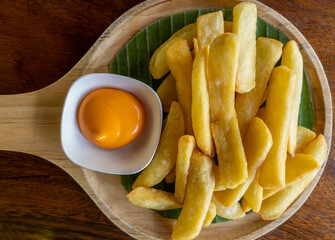 The golden french fries in the wooden plate.